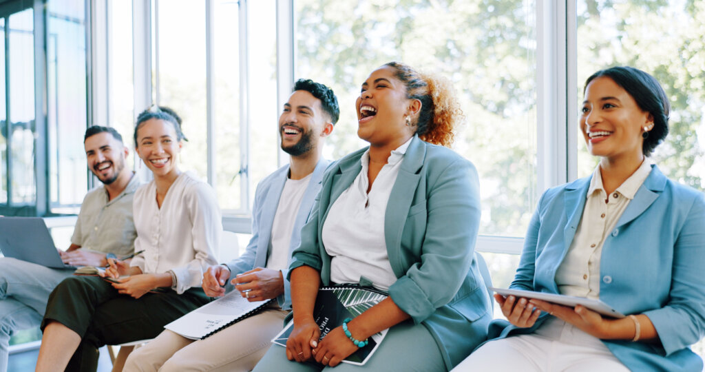Interview, question and training with a business black woman raising her hand to answer during a meeting. Recruitment, human resources and hiring with a candidate group sitting in a row at an office.